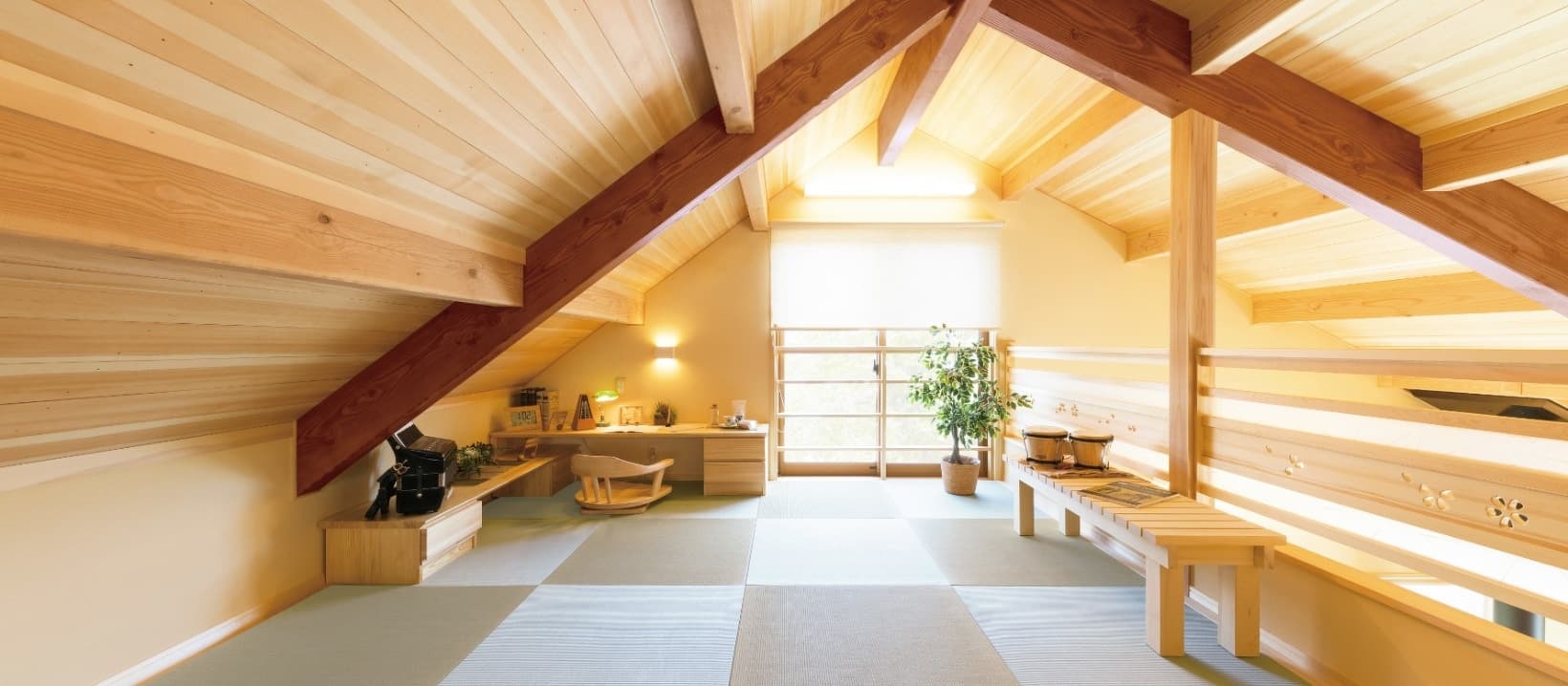 木の梁とやわらかな灯りに包まれた、板張り勾配天井の室内。